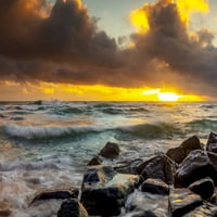 Izlazak sunca preko plaže i okeana s pranjem plime preko pijeska i stijena; Kauai, Havaji, Sjedinjene